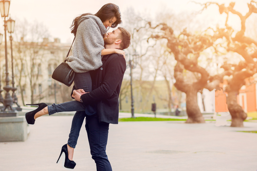 Loveandfriends man lifting woman in high heels in the air romantically